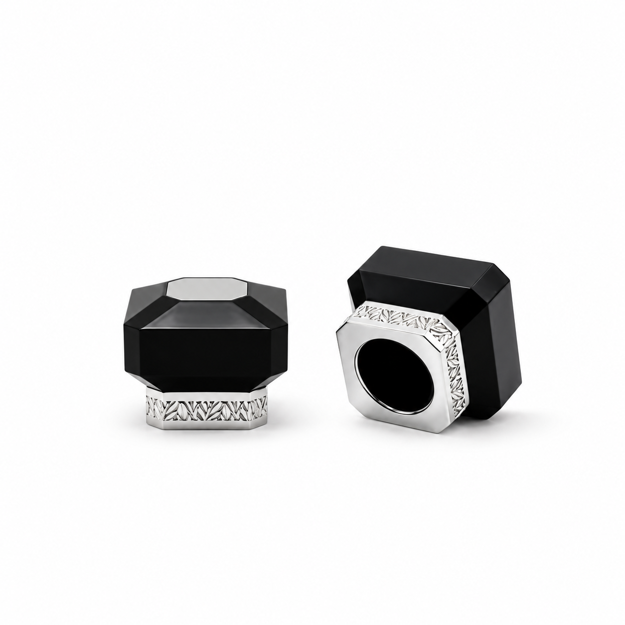 Black faceted perfume bottle cap with a silver top accent and patterned silver base, shown from the front.