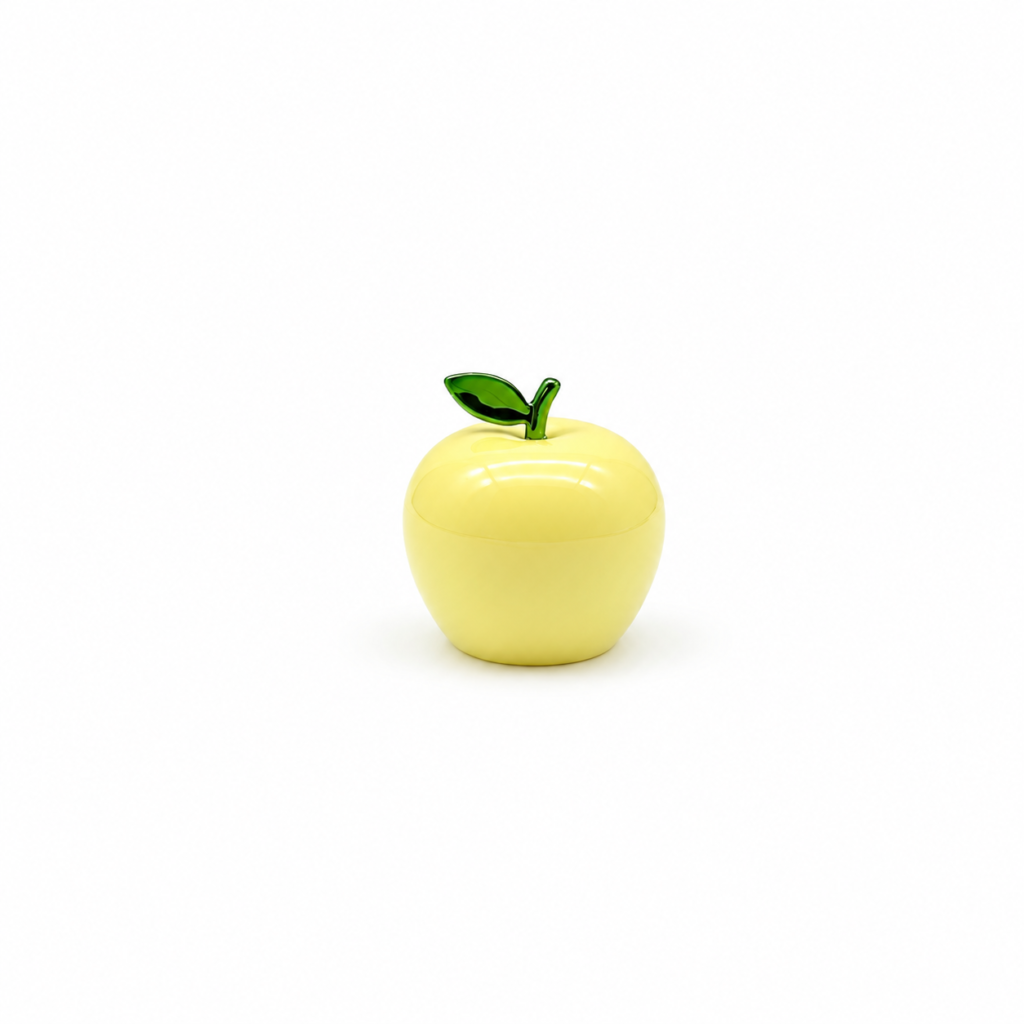 Yellow apple-shaped perfume cap with a green leaf, showing the front view and black-lined opening underneath.
