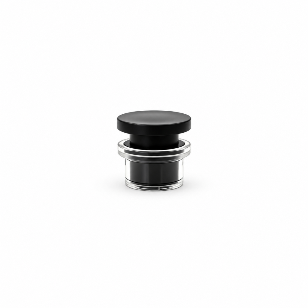 Perfume bottle cap with a black disc top and clear cylindrical outer shell, shown upright and tilted to reveal the bottom opening.